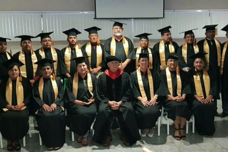 Fila de graduados de las Escuelas de Ministerio sosteniendo certificados
